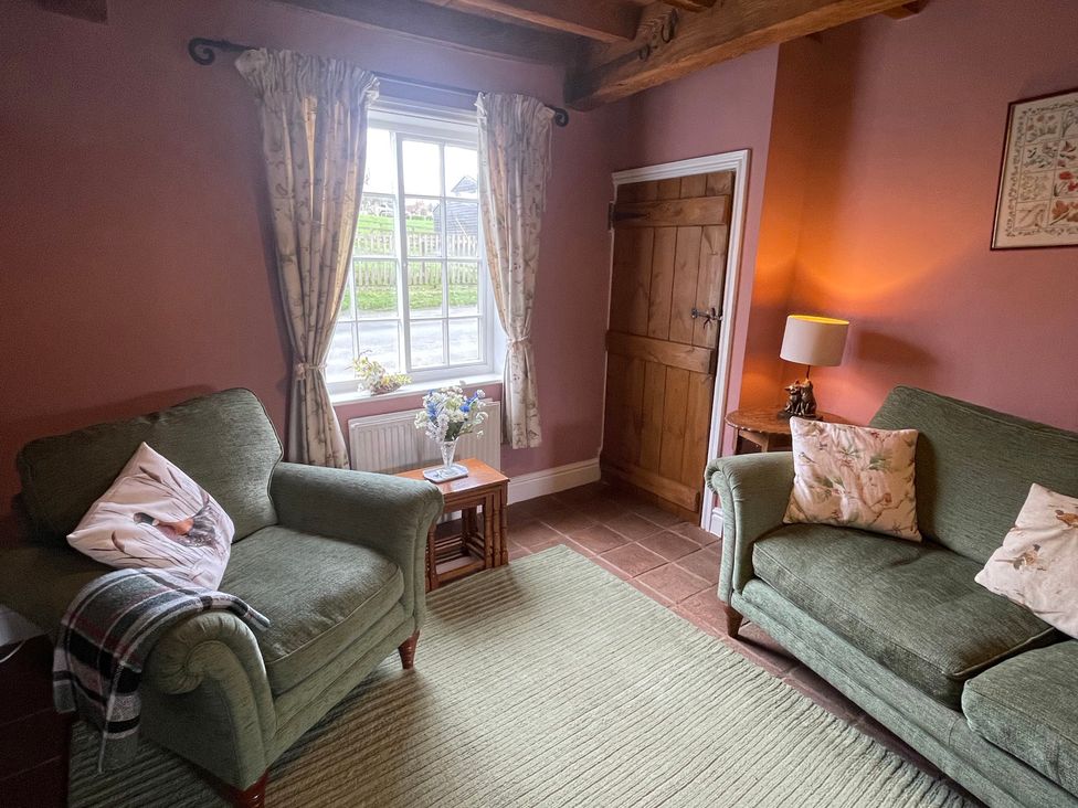 A living room with an armchair and sofa at Marmaduke Cottage in Market Weighton