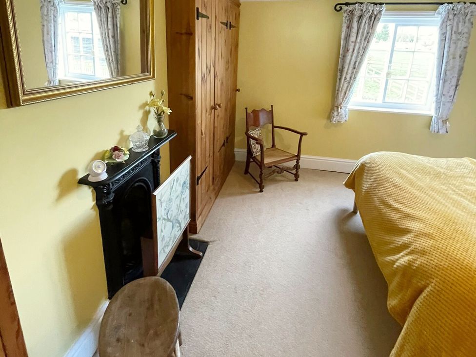 A bedroom with a bed and wardrobe at Marmaduke Cottage in Market Weighton