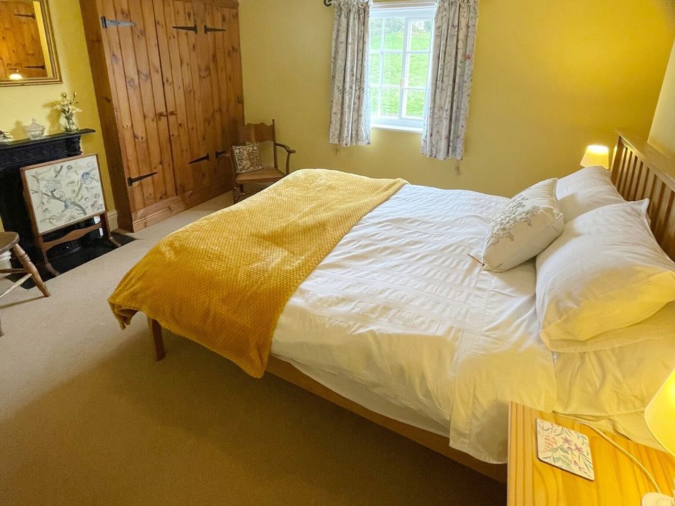 A bedroom with a bed and wardrobe at Marmaduke Cottage in Market Weighton