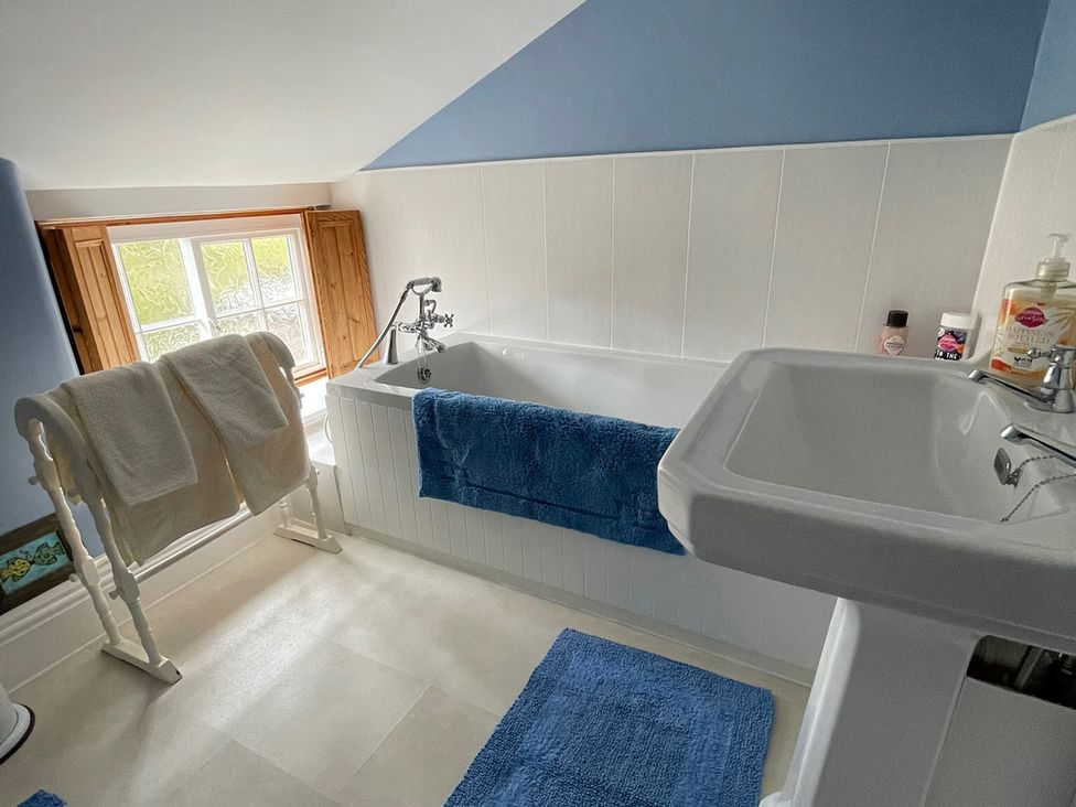 A bathroom with a bathtub and sink at Marmaduke Cottage in Market Weighton