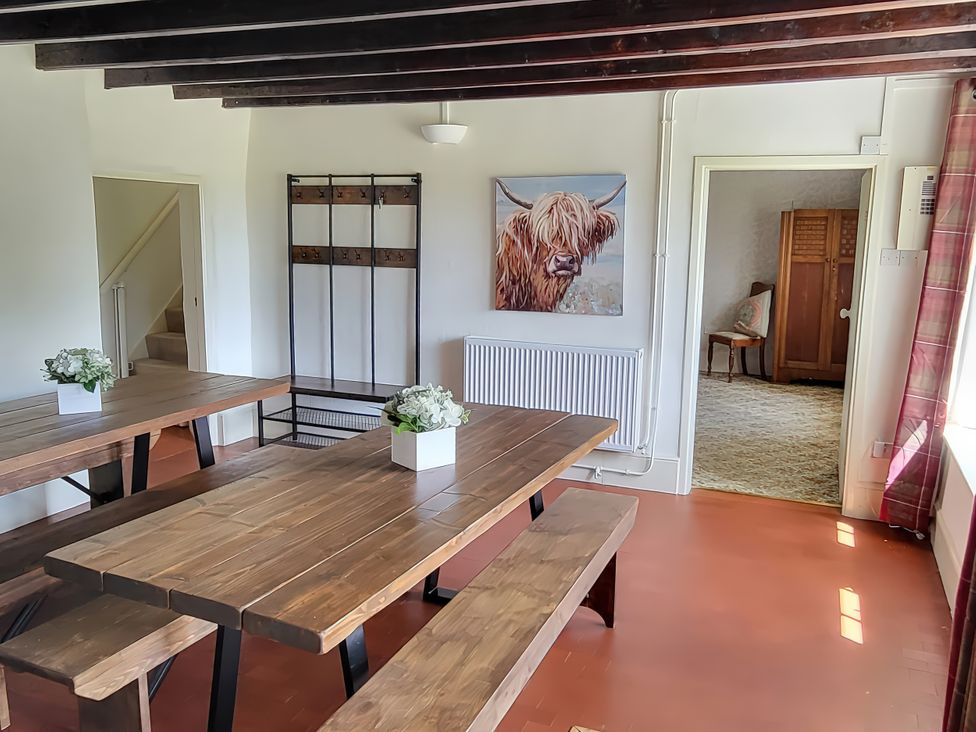 A dining room with a wooden table and benches at The Farmhouse in Youlgreave