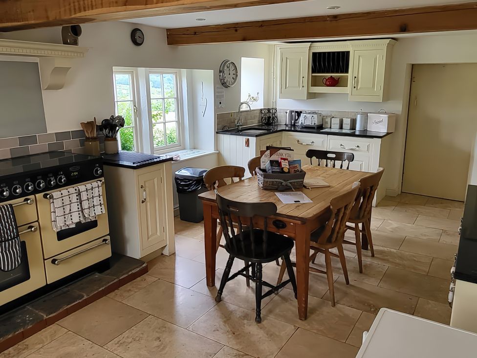 A kitchen with a table and chairs at The Farmhouse in Youlgreave