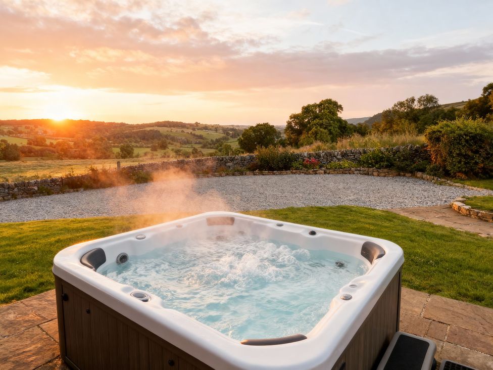 A hot tub outdoors with a sunset view at The Dairy in Middleton near Youlgreave