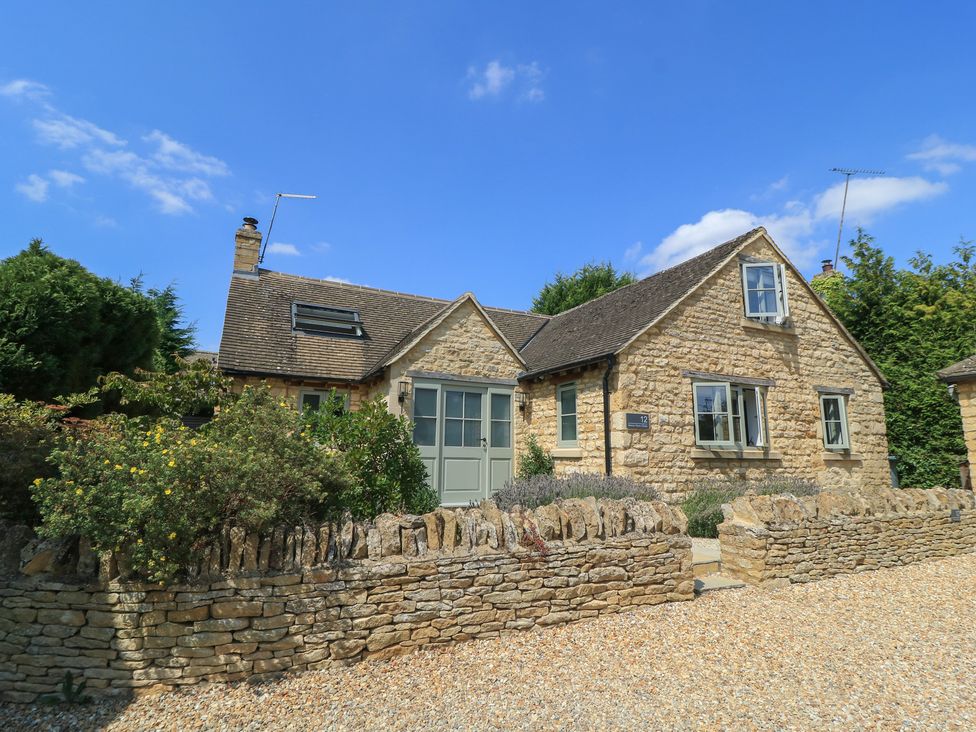 A house with stone walls and a gravel drive at 12 Manor Farm Close Kingham