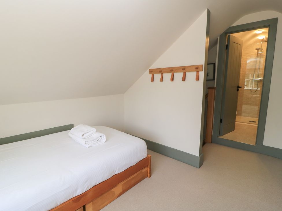 A bedroom with a bed and towels at 12 Manor Farm Close Kingham