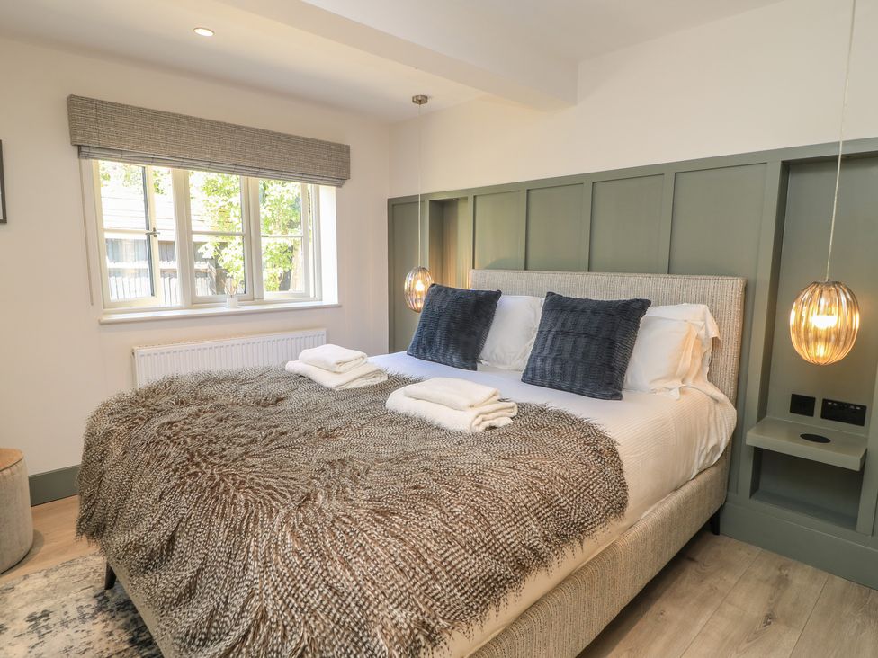 A bedroom with a bed and window at 12 Manor Farm Close Kingham
