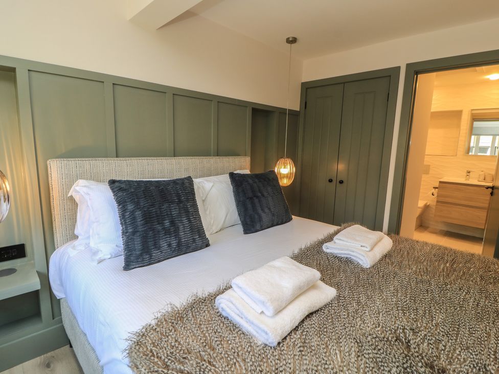 A bedroom with a bed and towels at 12 Manor Farm Close in Kingham