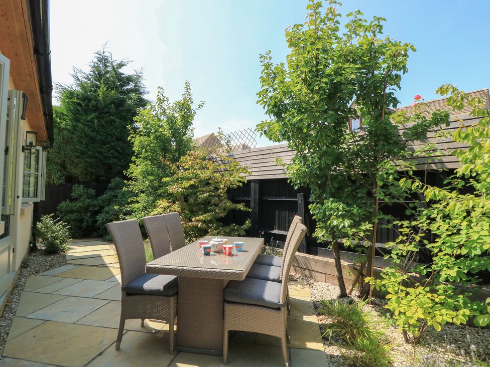 A garden with a dining set on a patio at 12 Manor Farm Close Kingham