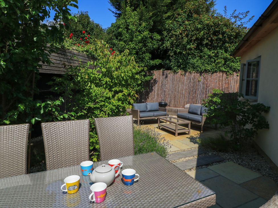 A patio with a table and chairs at 12 Manor Farm Close in Kingham