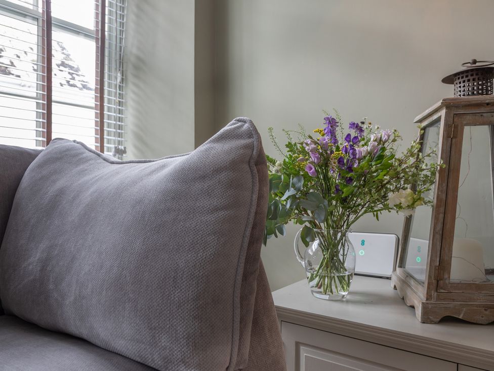 A living room with a couch and flowers on a table at George House in Dartmouth