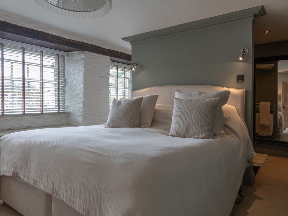 A bedroom with a bed and windows at George House Dartmouth