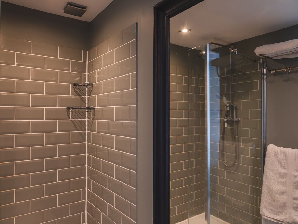 A bathroom with a shower and towel at George House in Dartmouth
