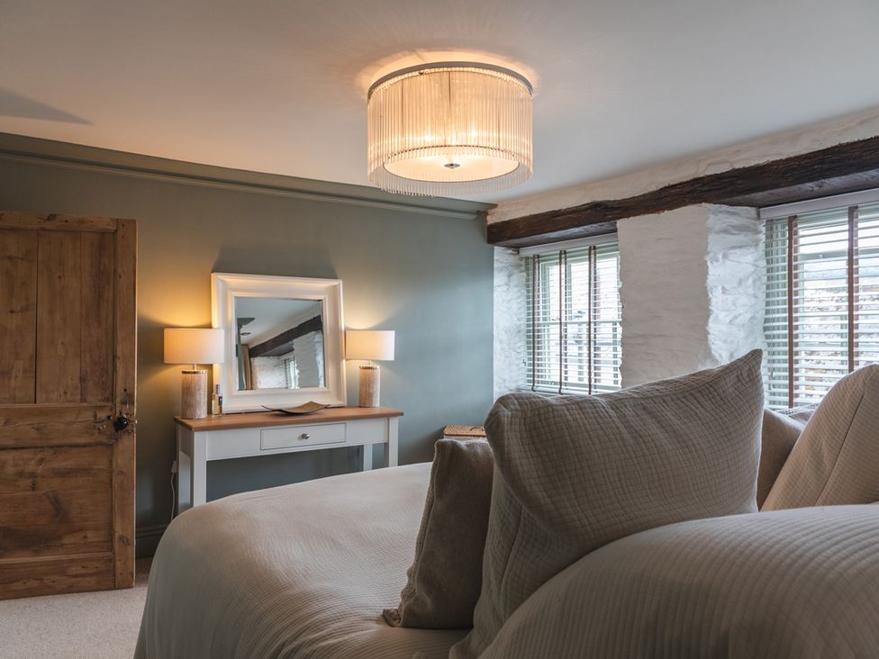 A bedroom with a bed and a mirror at George House in Dartmouth