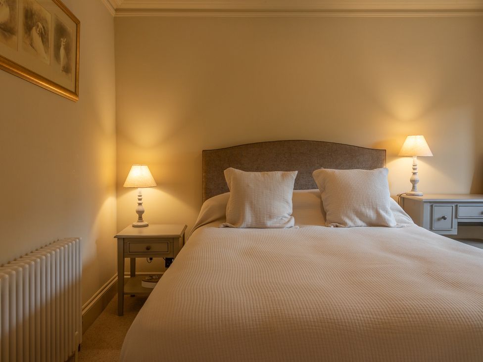 A bedroom with a bed and bedside tables at George House in Dartmouth