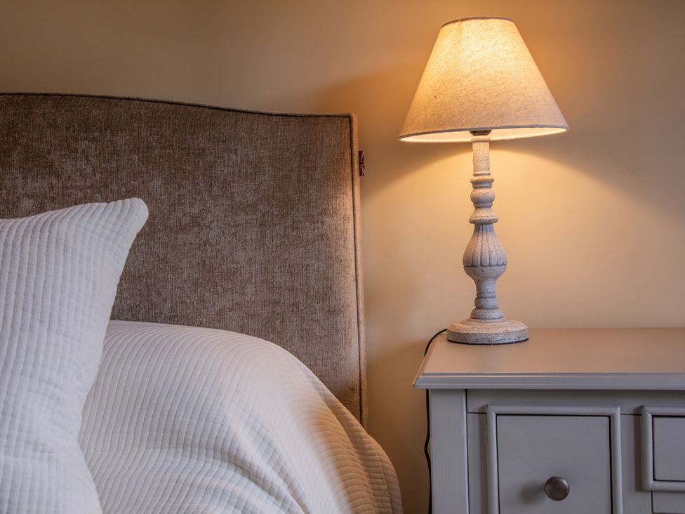 A bedroom with a bed, lamp, and nightstand at George House in Dartmouth