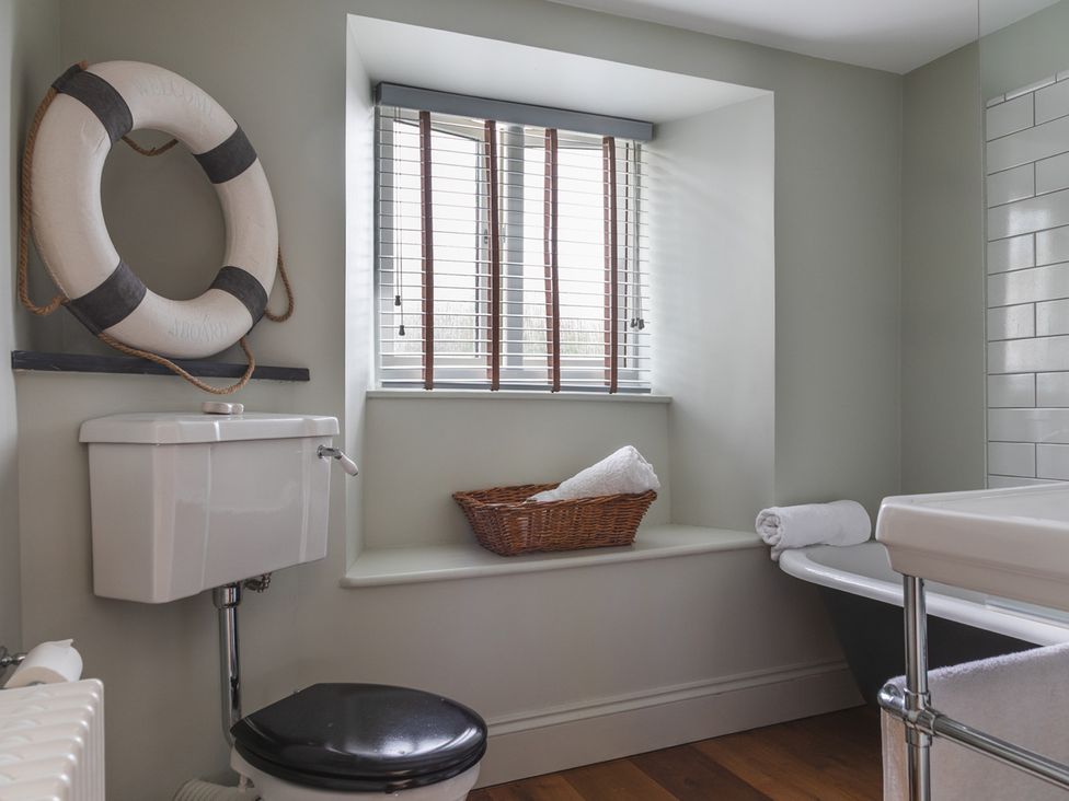 A bathroom with a bathtub and toilet at George House in Dartmouth
