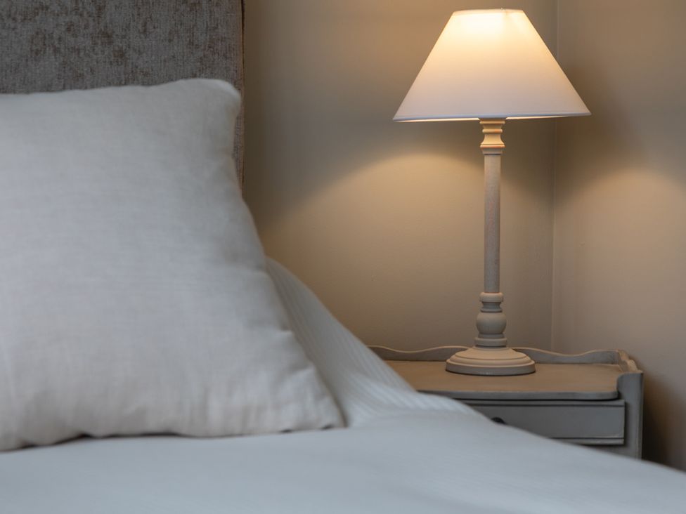 A pillow and lamp on a bedside table at George House in Dartmouth