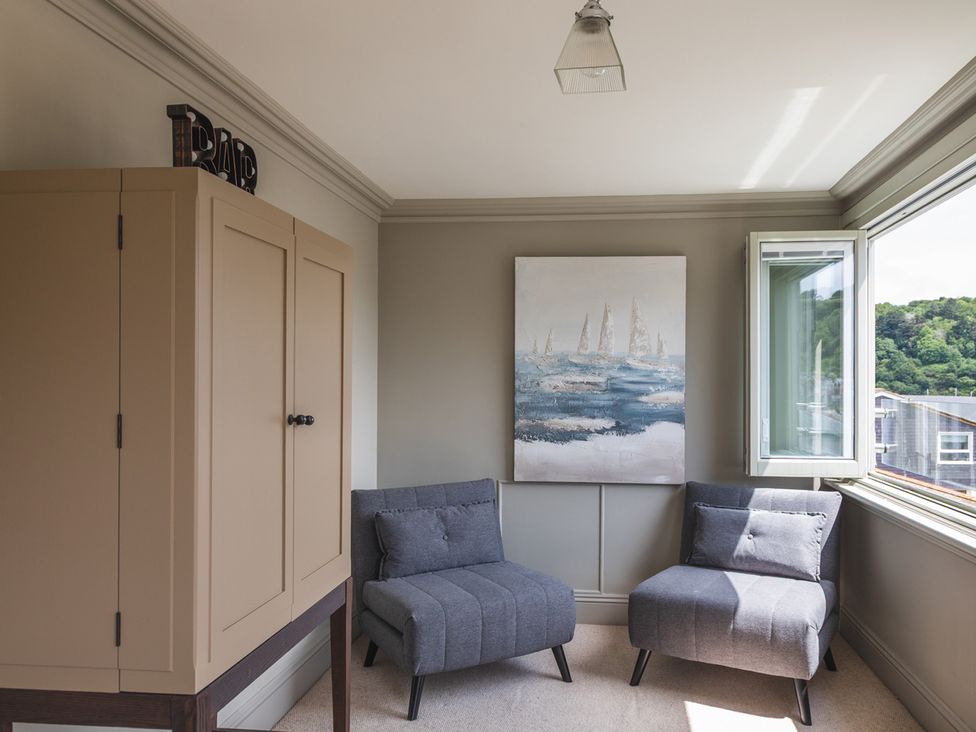 A sitting room with two armchairs and a cabinet at George House in Dartmouth