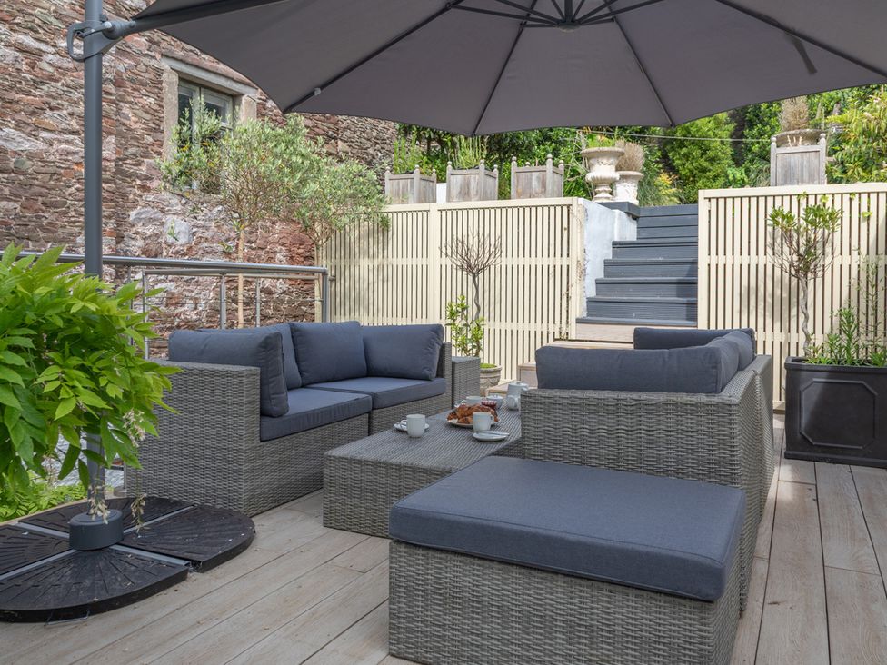 An outdoor seating area with couches and a table at George House in Dartmouth