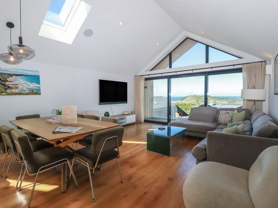 A living room with a dining table and sofa at Porth Cove in Porth