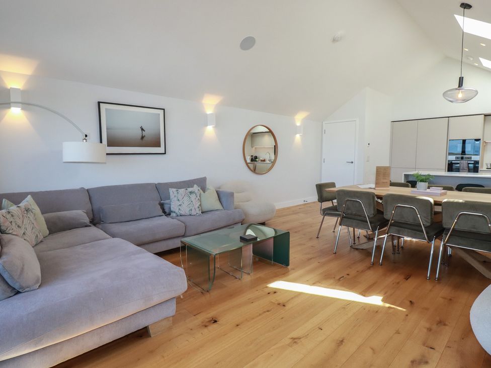 A living room with a sofa and dining table at Porth Cove in Porth