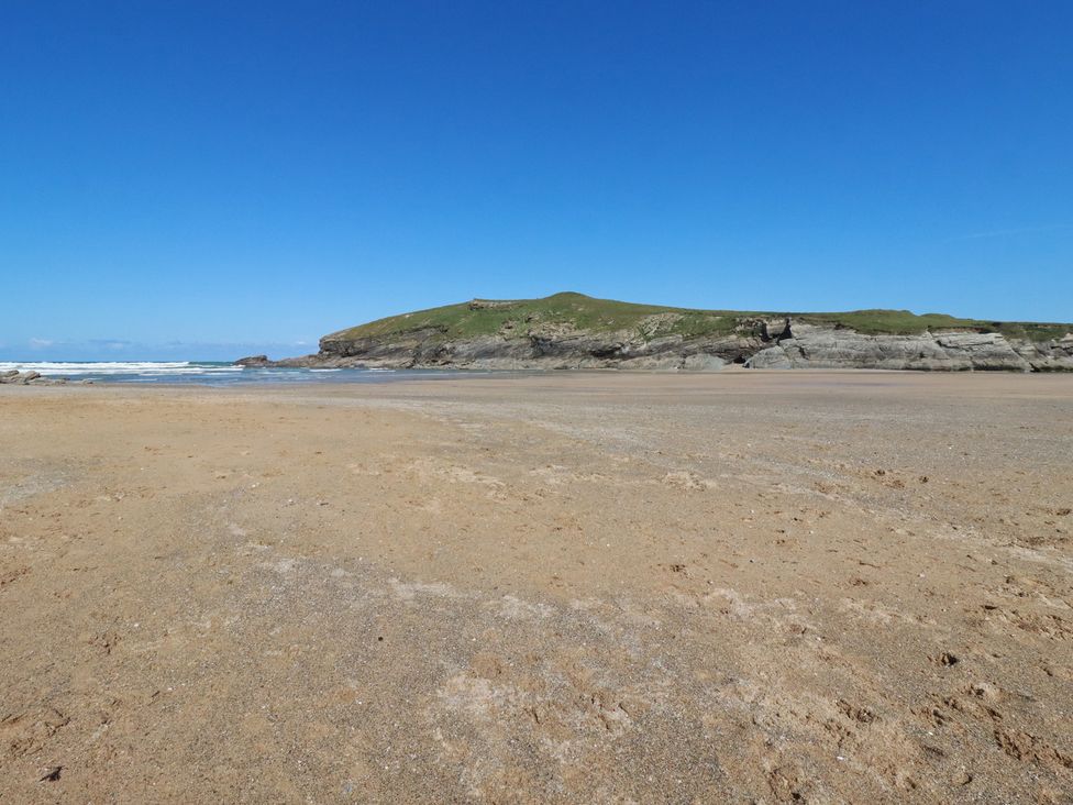 A beach with sand and ocean waves at Porth Cove in Porth