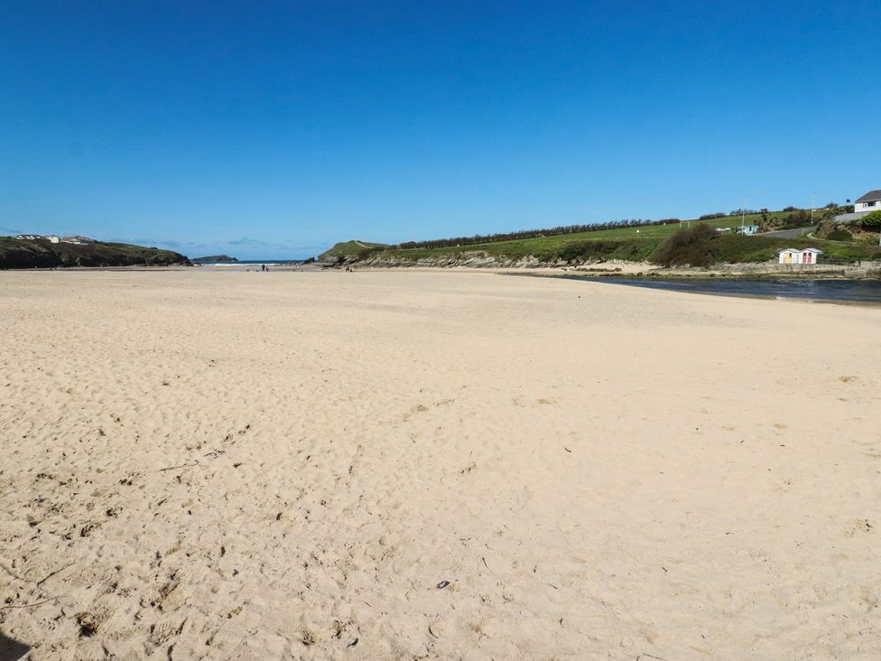 A beach with sand and hills at Porth Cove in Porth