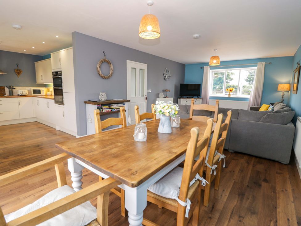 A dining room with a table and chairs at Cae Berllan Mynytho near Pwllheli