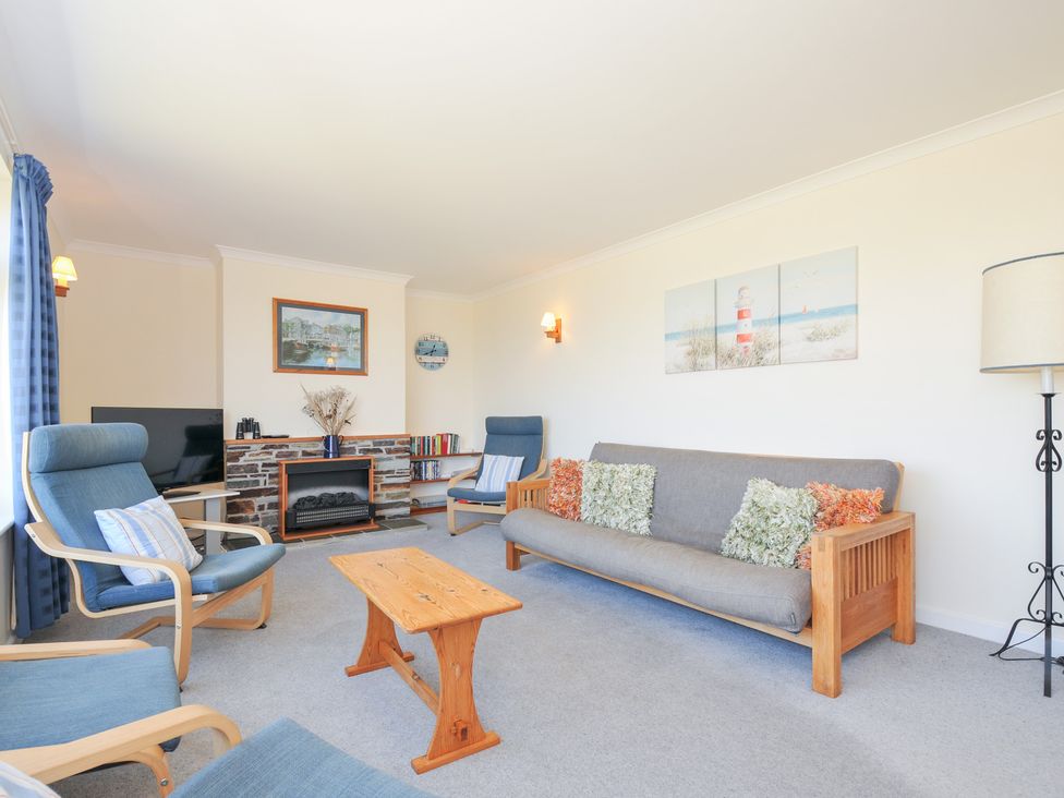A living room with seating and television at Zapadiah in Polzeath