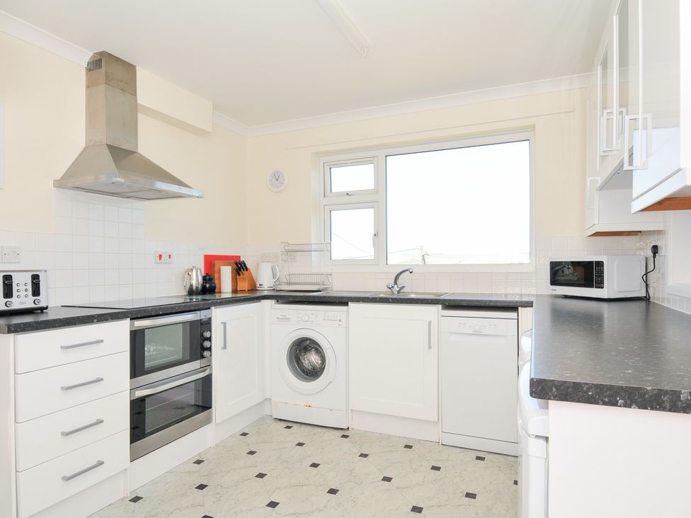 A kitchen with appliances including an oven and washing machine at Zapadiah in Polzeath