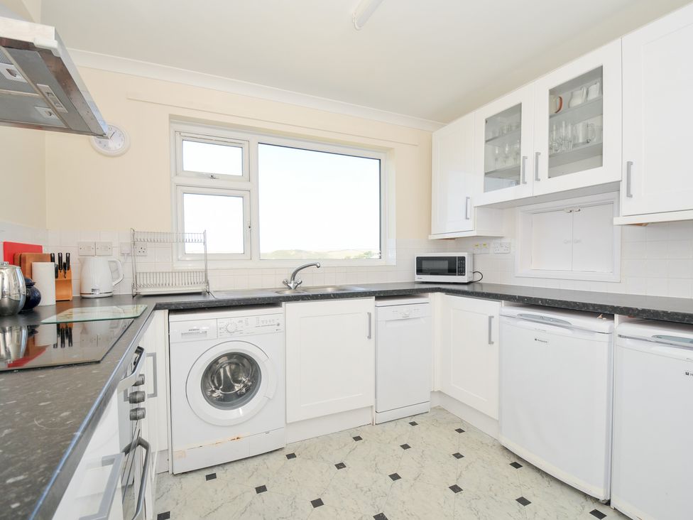 A kitchen with a washing machine and microwave at Zapadiah in Polzeath