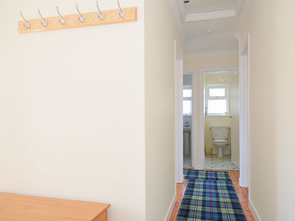 A hallway with coat hooks and a view of a toilet at Zapadiah in Polzeath