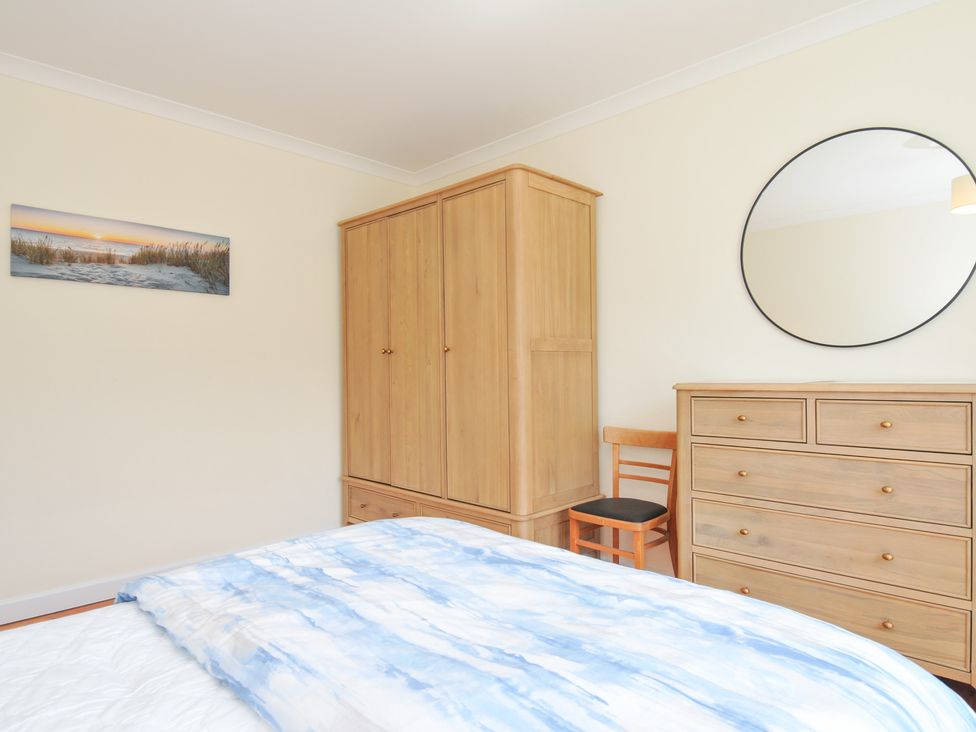 A bedroom with a bed and wardrobe at Zapadiah in Polzeath