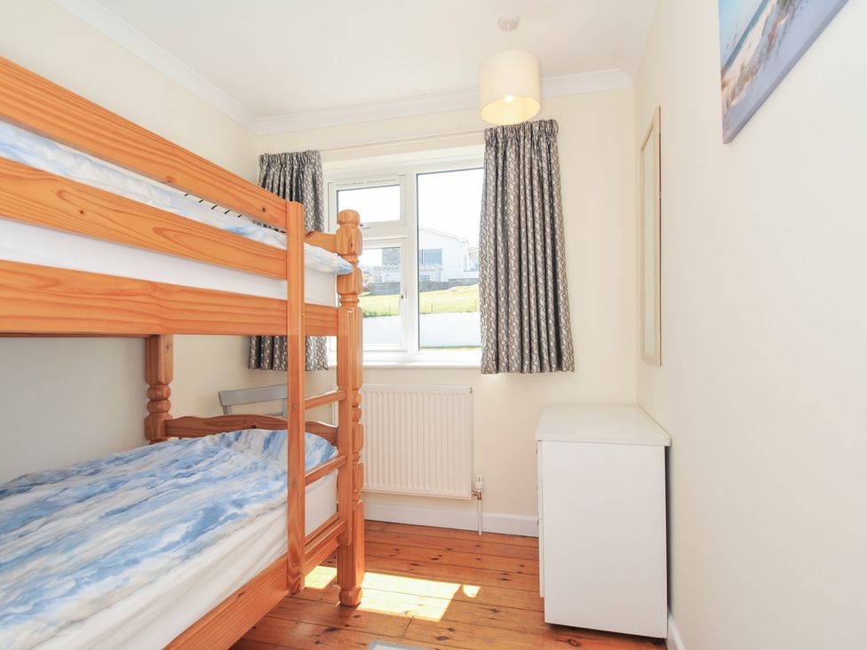 A bedroom with a bunk bed and a window at Zapadiah in Polzeath