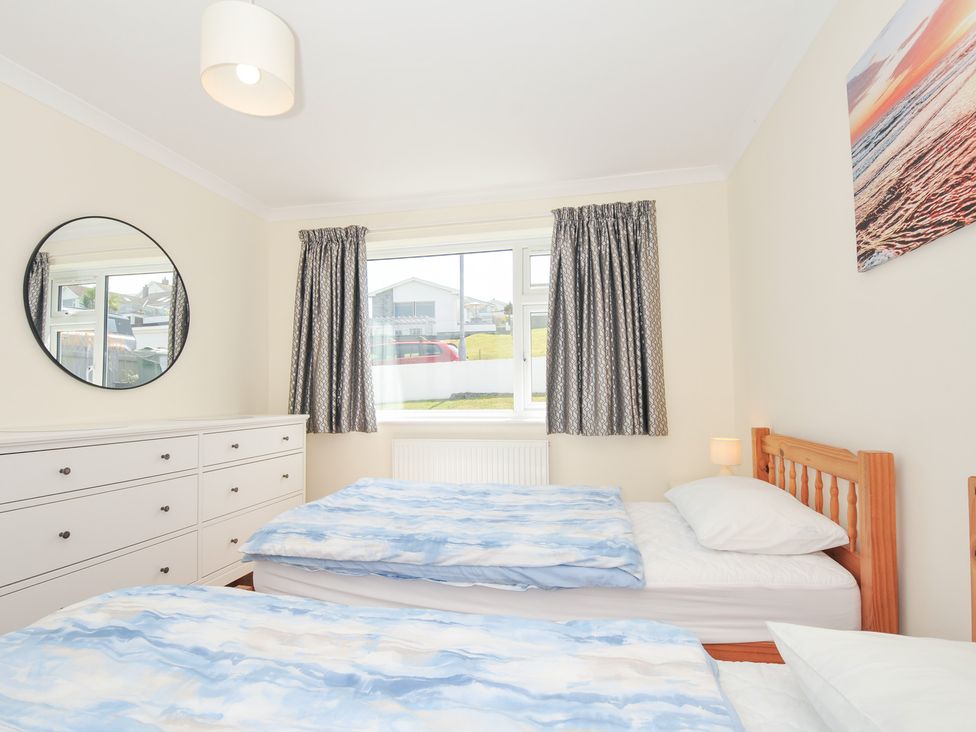 A bedroom with two beds and a mirror at Zapadiah in Polzeath