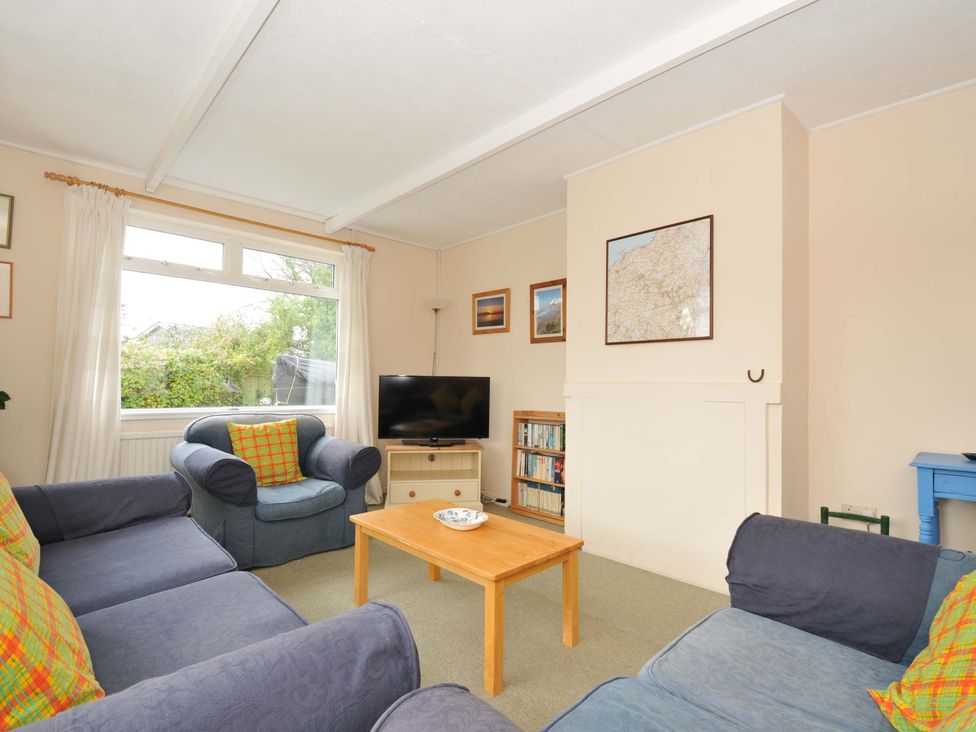 A living room with a television and a bookshelf at Avoca Rock