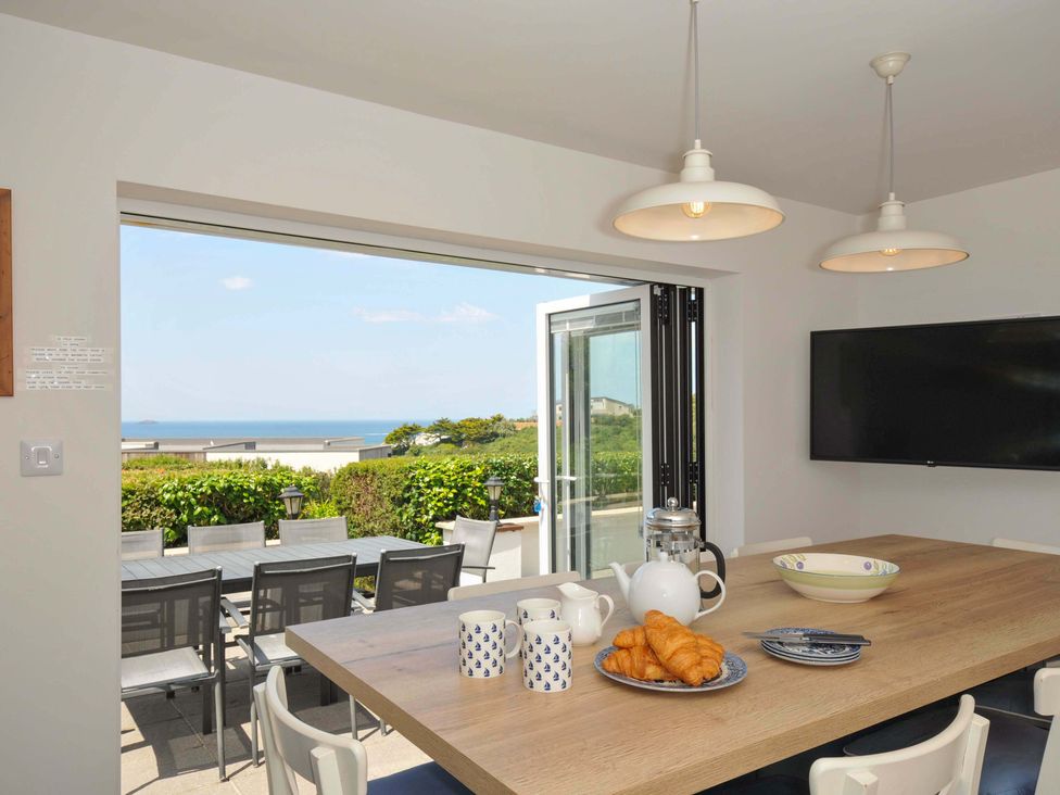 A dining room with a table set for breakfast at Sunset in Polzeath