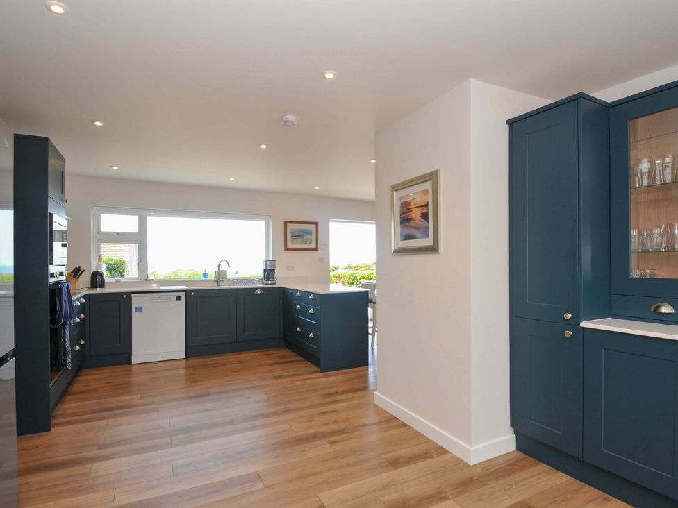 A kitchen with cabinets and a sink at Sunset in Polzeath