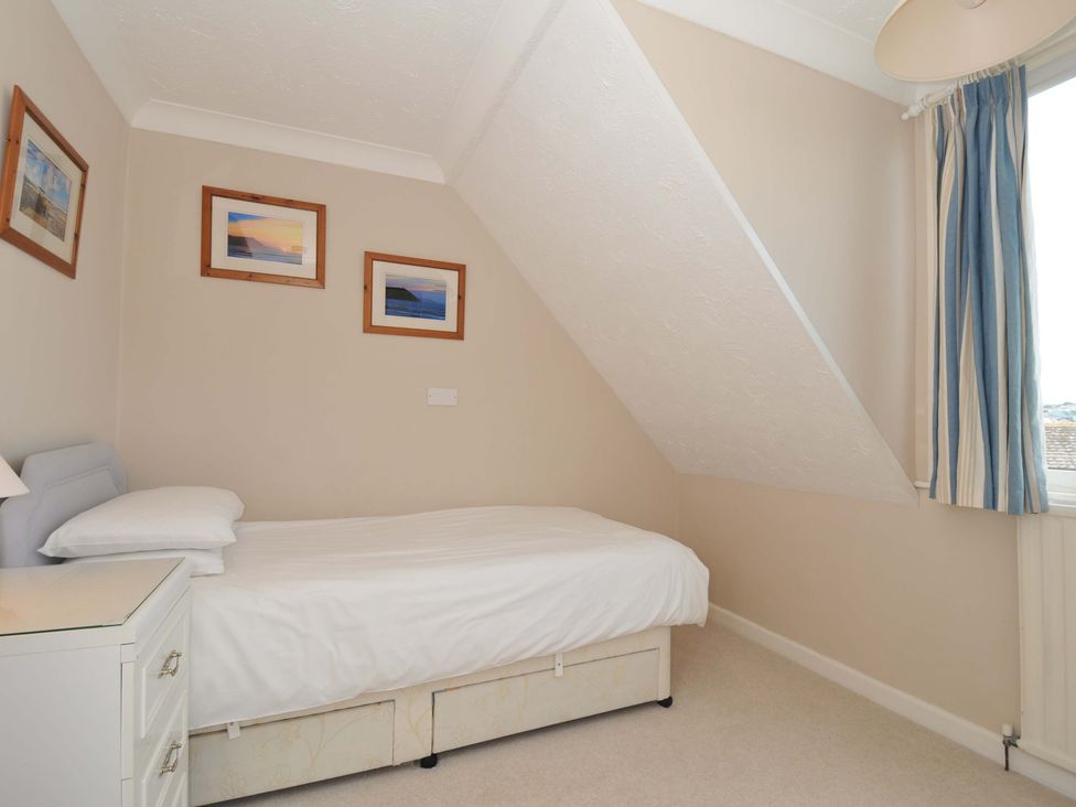 A bedroom with a bed and pictures on the wall at Sunset in Polzeath