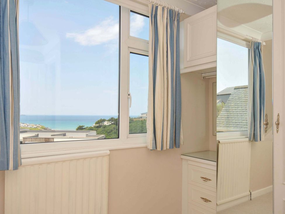 A bedroom with a window overlooking the sea at Sunset in Polzeath