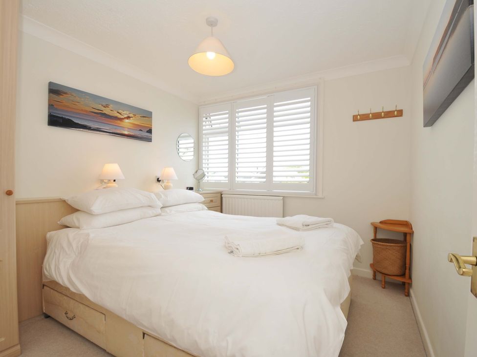 A bedroom with a bed and bedside lamps at Sunset in Polzeath