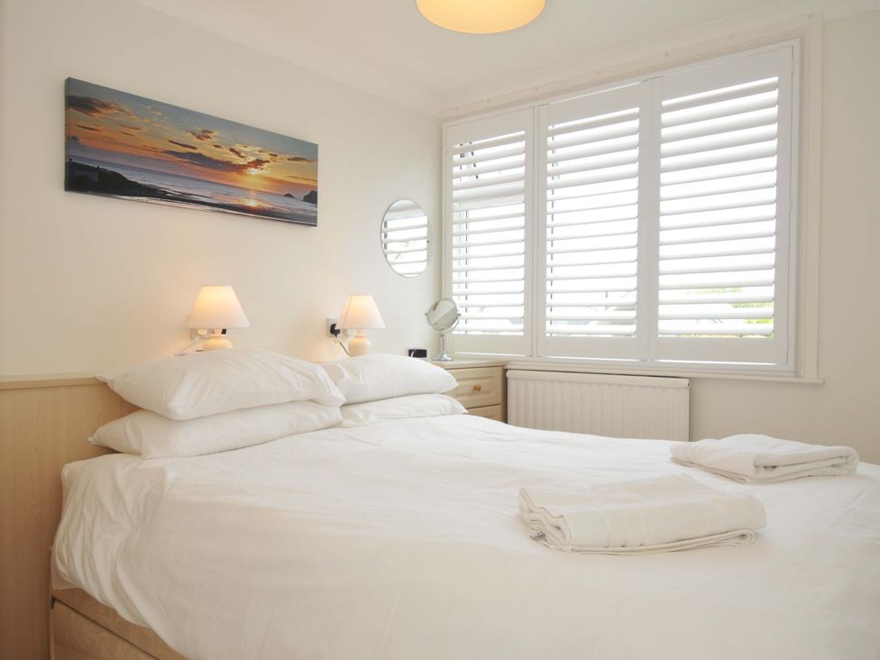 A bedroom with a bed and nightstand at Sunset in Polzeath
