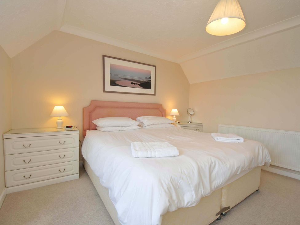 A bedroom with a bed and bedside tables at Sunset in Polzeath