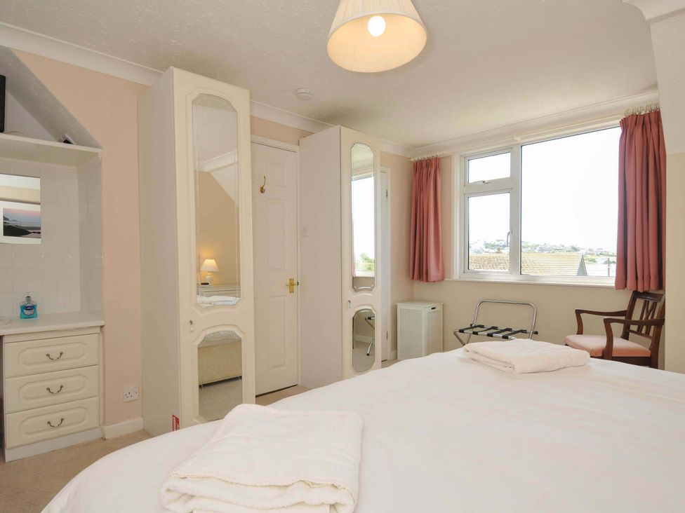 A bedroom with a double bed and wardrobe at Sunset in Polzeath