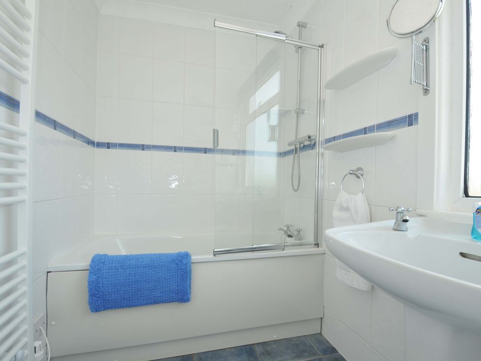 A bathroom with a bathtub and sink at Sunset in Polzeath