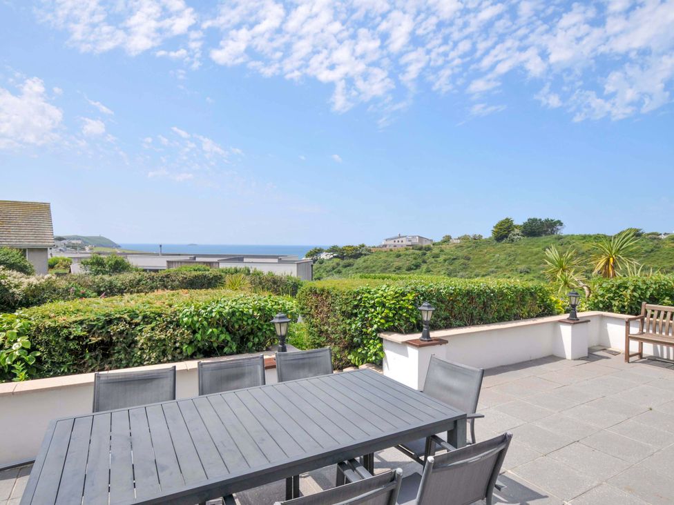 A patio with a dining table and chairs at Sunset in Polzeath