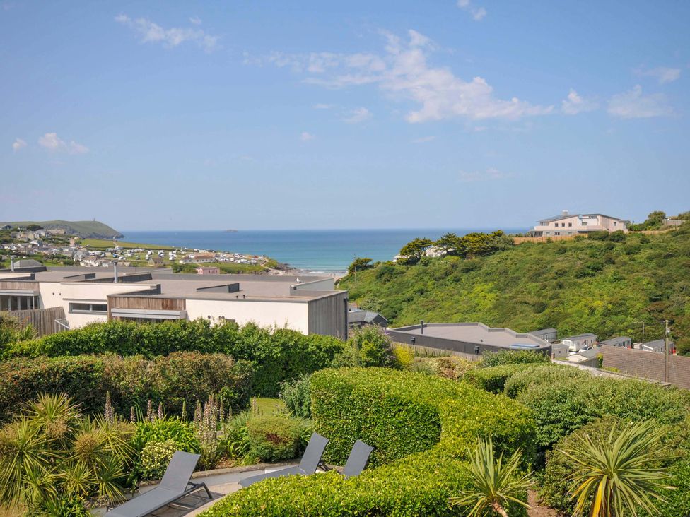 A view of houses and the sea from a garden at Sunset in Polzeath