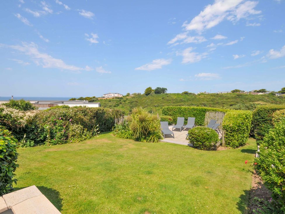 A garden with seating and grass at Sunset in Polzeath