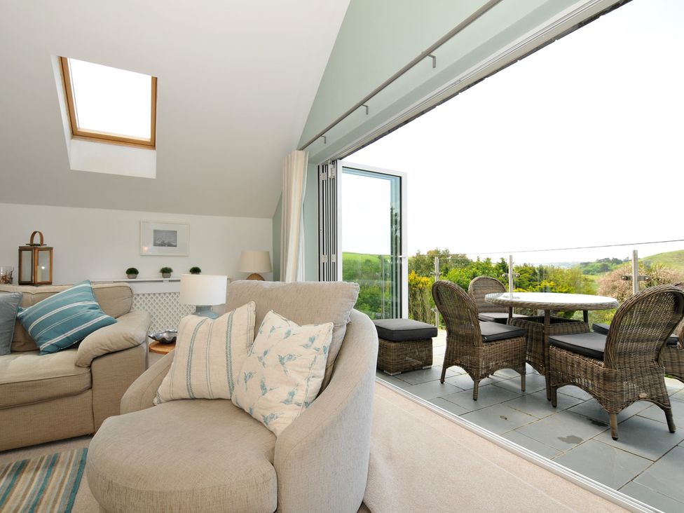 A living room with a sofa and armchair at Farlands in Daymer Bay