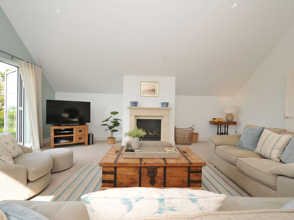 A living room with a coffee table and television at Farlands in Daymer Bay